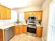 An efficient kitchen with stainless steel appliances and warm-toned cabinets and countertops at 4130 Town Center Rd, Harrisburg, NC 28075