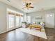 The well-lit living room features hardwood floors, two couches, ceiling fan, and large windows at 4130 Town Center Rd, Harrisburg, NC 28075