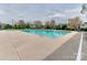 Large community pool with lounge chairs and umbrellas on a cloudy day at 4130 Town Center Rd, Harrisburg, NC 28075
