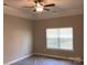 Bright bedroom with a ceiling fan, large window, and neutral walls, offering a cozy atmosphere at 5126 Rocky River Crossing Rd, Harrisburg, NC 28075