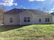 Rear exterior view showing the home's backyard, neutral siding, roofline and well-maintained lawn at 5126 Rocky River Crossing Rd, Harrisburg, NC 28075