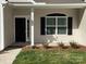 Inviting front entrance with black door, detailed trim, and manicured landscaping at 5126 Rocky River Crossing Rd, Harrisburg, NC 28075