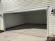 Open two car garage that is attached to the home with exterior lighting and access to the home at 5126 Rocky River Crossing Rd, Harrisburg, NC 28075
