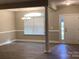 Open-concept living room with modern lighting, neutral colors, and wood-look floors at 5126 Rocky River Crossing Rd, Harrisburg, NC 28075