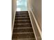 Carpeted stairway leading to the upper level, featuring a white handrail, prepared for new owners at 5126 Rocky River Crossing Rd, Harrisburg, NC 28075