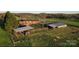 Aerial view of farmhouse, barn, fenced yard, and surrounding farmland, offering a tranquil setting at 5373 Nc Hwy 16 N Hwy, Taylorsville, NC 28681