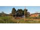 Farmhouse exterior with multiple buildings, fenced yard, and mature trees on a sunny day at 5373 Nc Hwy 16 N Hwy, Taylorsville, NC 28681