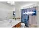 A clean, well-lit bathroom with a large mirror and a shower with a blue patterned curtain at 6115 The Meadows Ln, Harrisburg, NC 28075
