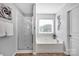 Bathroom featuring a bathtub and a glass enclosed shower at 6115 The Meadows Ln, Harrisburg, NC 28075
