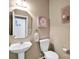 Half bathroom featuring a pedestal sink, decorative mirror, and a neutral color palette at 6115 The Meadows Ln, Harrisburg, NC 28075