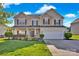 Charming two-story home featuring a manicured lawn and welcoming front porch with beautiful landscaping at 6115 The Meadows Ln, Harrisburg, NC 28075