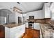 Bright kitchen features stainless appliances, granite countertops and wood floors at 6115 The Meadows Ln, Harrisburg, NC 28075