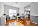 Bright home office with hardwood floors, a large window, and a view into the kitchen area at 6115 The Meadows Ln, Harrisburg, NC 28075