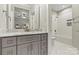 Bathroom featuring a large mirror, gray cabinets, and a shower/tub combo at 6654 Maple Spring Ct, Denver, NC 28037