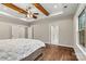 Bedroom with hardwood floors, a ceiling fan, a doorway to the bathroom, and a closet providing ample storage space at 6654 Maple Spring Ct, Denver, NC 28037