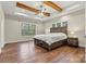 Spacious bedroom with hardwood floors, exposed wooden beams, a ceiling fan, and multiple windows for ample natural light at 6654 Maple Spring Ct, Denver, NC 28037