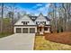 Beautiful home featuring a three-car garage, brick accents, and a well-manicured lawn at 6654 Maple Spring Ct, Denver, NC 28037
