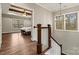 Hallway staircase showcasing hardwood floors and a view of the bedroom with exposed wooden beams and abundant natural light at 6654 Maple Spring Ct, Denver, NC 28037