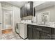 Functional laundry room with a washer, dryer, dark cabinets, decorative flooring, and a sink area offering practical convenience at 6654 Maple Spring Ct, Denver, NC 28037
