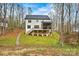 View of the home's rear exterior with a well-maintained yard and screened porch at 6654 Maple Spring Ct, Denver, NC 28037