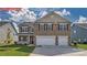 Two-story home with brick and siding, two-car garage, landscaped lawn, and inviting curb appeal at 7330 Stonehouse Dr, Gastonia, NC 28056