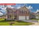 Two-story home with brick and siding, two-car garage, landscaped lawn, and inviting curb appeal at 7330 Stonehouse Dr, Gastonia, NC 28056