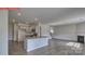 A view of the spacious living room and kitchen area with an island, fireplace, and stainless steel appliances at 7330 Stonehouse Dr, Gastonia, NC 28056