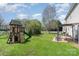 Landscaped backyard features a playset, swing set, pergola, and patio at 9013 Gailes Dr, Charlotte, NC 28278