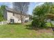 Spacious backyard with green grass, mature trees, patio set, and white picket fence at 9013 Gailes Dr, Charlotte, NC 28278