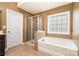 Bathroom featuring a soaking tub, glass enclosed shower, tile floor, and neutral paint at 9013 Gailes Dr, Charlotte, NC 28278