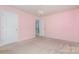 Bedroom has pink walls, carpet, chandelier and closet door at 9013 Gailes Dr, Charlotte, NC 28278
