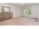 Neutral bedroom featuring a dresser and large window at 9013 Gailes Dr, Charlotte, NC 28278