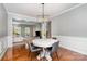 Bright dining area with hardwood floors, modern light fixture, and seamless flow to living room at 9013 Gailes Dr, Charlotte, NC 28278
