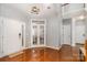 Bright foyer with hardwood floors, a staircase, and French doors leading to a living space at 9013 Gailes Dr, Charlotte, NC 28278