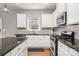 Modern kitchen featuring white cabinets, gray backsplash, and stainless steel appliances at 9013 Gailes Dr, Charlotte, NC 28278