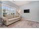 Cozy carpeted living room with a comfortable sofa and a large window offering natural light at 9013 Gailes Dr, Charlotte, NC 28278