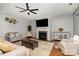 Elegant living room with a fireplace, hardwood floors, and modern ceiling fan at 9013 Gailes Dr, Charlotte, NC 28278