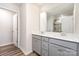 Bathroom featuring double sink vanity, well-lit mirror, and wood flooring at 9654 Old Garden Cir, Gastonia, NC 28056