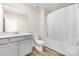 Bright bathroom featuring a gray vanity, a modern faucet, and a shower tub with a curtain at 9654 Old Garden Cir, Gastonia, NC 28056