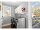 Laundry room featuring modern washer and dryer, white cabinetry, and access to a deck at 9718 Barkridge Rd, Mint Hill, NC 28227