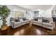 Bright living room featuring hardwood floors, a large window, and two comfortable gray sofas at 9718 Barkridge Rd, Mint Hill, NC 28227
