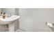This bathroom features a pedestal sink, modern fixtures, and neutral tones at 10002 Brittondale Ln, Charlotte, NC 28215