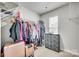 Functional walk-in closet providing ample storage with shelving, drawer unit, and carpeted floor at 10002 Brittondale Ln, Charlotte, NC 28215