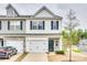 Charming townhome with a two-car garage, stone accents, and a well-maintained front yard at 10002 Brittondale Ln, Charlotte, NC 28215