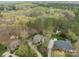 Drone shot of homes with curved driveways, well-manicured lawns, and mature trees in a residential area at 104 Chalfont Ct, Salisbury, NC 28147