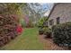 Well-landscaped backyard showcasing vibrant azaleas, lush greenery, and a beautiful brick home at 104 Chalfont Ct, Salisbury, NC 28147