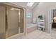 Bathroom with glass shower, jacuzzi tub, and decorative window at 104 Chalfont Ct, Salisbury, NC 28147