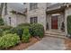Inviting front entrance with a stylish wood door framed by lush landscaping, creating a warm and welcoming ambiance at 104 Chalfont Ct, Salisbury, NC 28147