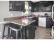 A functional kitchen has dark cabinets, an island with seating and neutral countertops at 109 Connor Ct, Kings Mountain, NC 28086