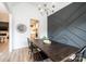A dining room features a wood table, a modern gray accent wall, and a view into the kitchen and a fireplace at 112 Whitman Ct # 275, Taylorsville, NC 28681
